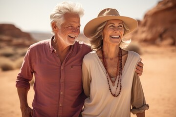 Stylish Senior Couple Enjoying Desert Expedition. Smiling elegantly dressed senior couple embracing in a desert, enjoying the vista