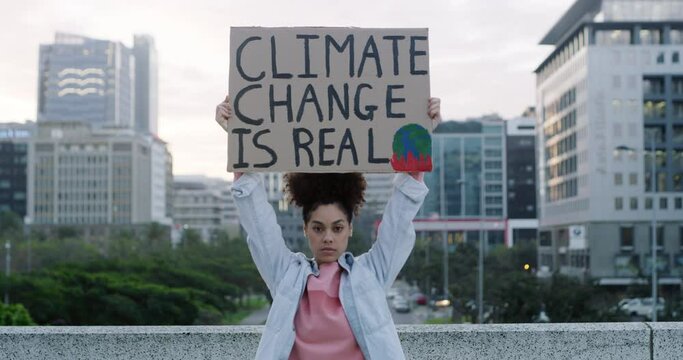 Woman, billboard and protest in city for earth day, save the planet or climate change in outdoor march. Portrait of female person or activist with cardboard poster, placard or sign for global warming
