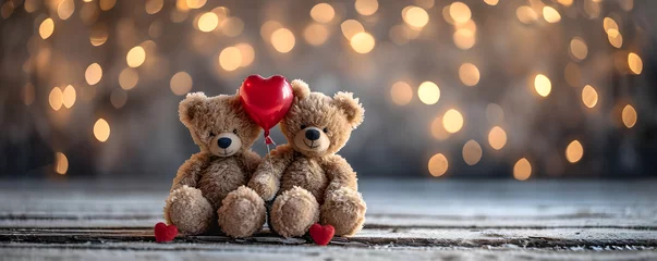 Tuinposter Two teddy bears with a red heart shaped balloon on blurred background with golden lights. Cute bear couple toy hugging and holding heart. Valentine's day. Love and romantic concept © ratatosk