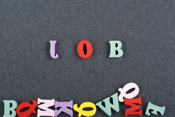JOB word on black board background composed from colorful abc alphabet block wooden letters, copy...