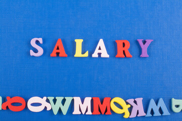 SALARY word on blue background composed from colorful abc alphabet block wooden letters, copy space for ad text. Learning english concept.