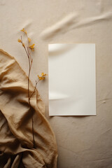 Blank sheet of paper and dried flowers on beige background.
