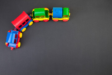 Children's toy, a multi-colored steam locomotive on a black background.