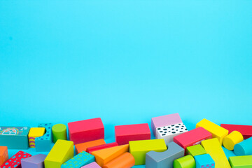 Top view of colorful wooden bricks on the table. Early learning. Educational toys on a blue background.