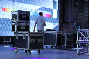 Technicians working setting up a stage with giant LED screens. Drawers for carrying equipment for...