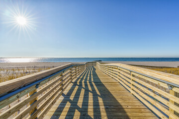 Boardwalk on the Lido beach Long Island leading to the water. - obrazy, fototapety, plakaty