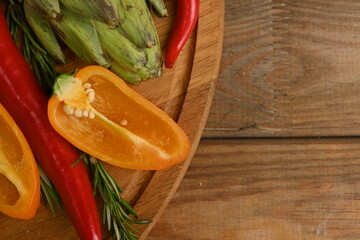 Overhead view of fresh and raw artichoke on the wooden table, vegetable composition bitter pepper, yellow pepper free place for text 