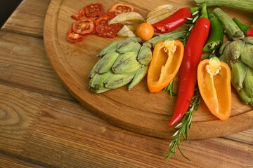 Overhead view of fresh and raw artichoke on the wooden table, vegetable composition bitter pepper, yellow pepper free place for text 