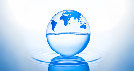 crystal-clear sphere with an imprint of the Earth continents, partially submerged in water against a serene blue background. Suitable for World Water Day, environmental day or earth day to raise