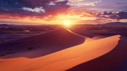   the sun is setting over a desert with sand dunes in the foreground and mountains in the distance in the distance, with clouds in the sky, and in the foreground. © Anna