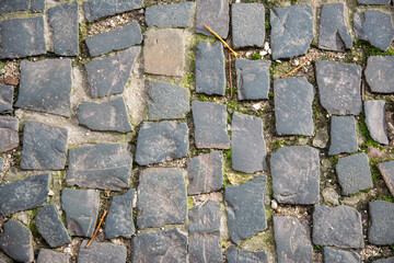 Stone wall with old bricks in the city. Gray stone block surface.