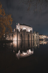 Night portrait of the medieval Gravesteen Castle in the centre of Ghent, Belgium. The reflection of...