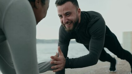 Diverse fitness duo performing a high five plank exercise outdoor. Showcases teamwork, strength, and a fun workout between friends. - Powered by Adobe