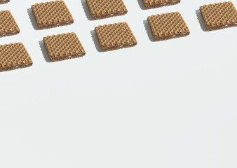 Obraz na płótnie Canvas Waffles geometrically laid out on a white background. Copy space. Sweets minimal concept.