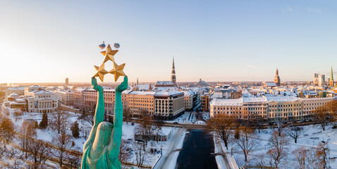 Beautiful sunrise panorama  over Riga by the statue of liberty - Milda in Latvia. The monument of...