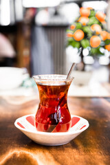 A glass of black Turkish tea on wooden table