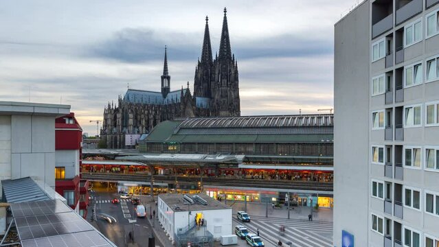 Cologne Germany city skyline aerial view time lapse from day to night in front cologne cathedral dome with main station tram people walking in front.