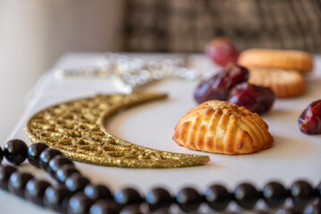 Variety of semolina maamoul cookies displayed with crescent ,star and Ramadan decorations. Traditional Arabic sweets for Eid al Adha and Eid al Fitr celebrations.