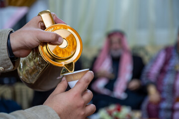 hands for male puring arabic coffee for guests in family time