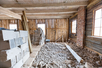 Interior renovation in progress with exposed wooden beams and pile of rubble on the floor in an old...