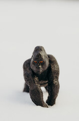 One toy black gorilla on a snowy background.