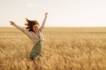 Caught in a burst of joy, a woman dances freely in the wheat field, her figure silhouetted against...