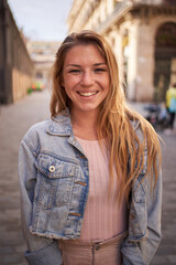 Vertical close up portrait cheerful attractive young Caucasian woman happy smiling on street....