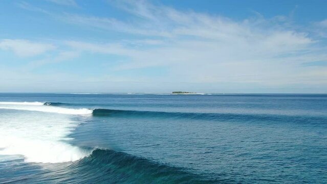Perfect waves for surfing break along shallow coral reef in Fiji