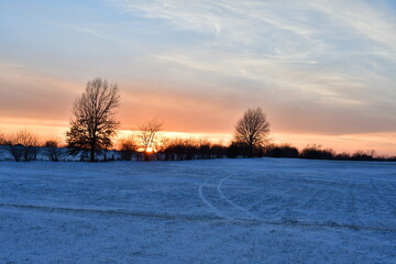 Fototapeta na wymiar Sunset Over a Snowy Field