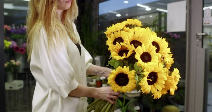 florist in a flower store shows sunflowers