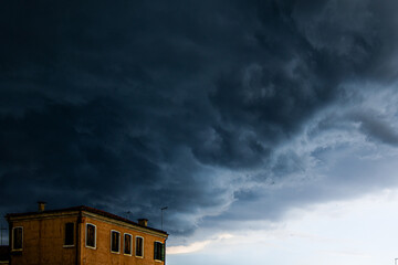 Dark textured and voluminous clouds before rain. Dark clouds and building