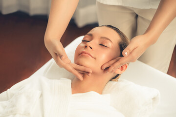 Fototapeta na wymiar Caucasian woman enjoying relaxing anti-stress head massage and pampering facial beauty skin recreation leisure in dayspa modern light ambient at luxury resort or hotel spa salon. Quiescent
