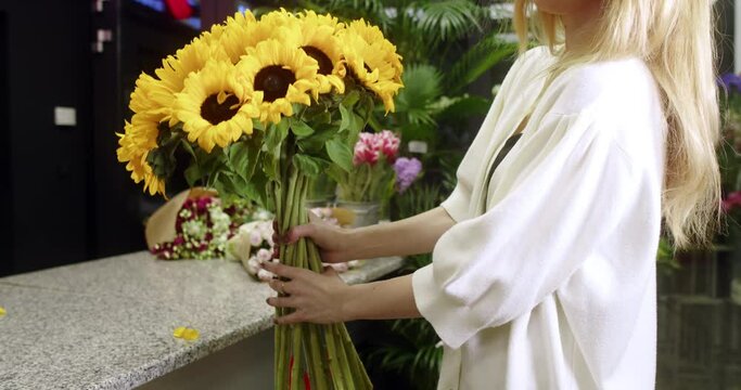 florist in a flower store shows sunflowers
