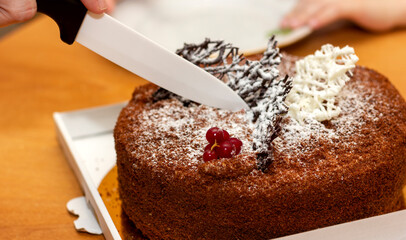 cutting a chocolate birthday cake with a knife close-up
