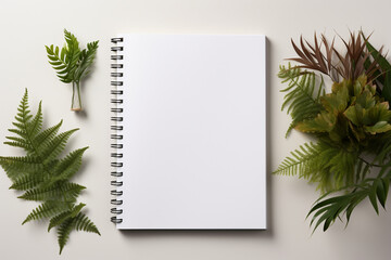 Design concept - top view of notebook with green plant on white background for mockup
