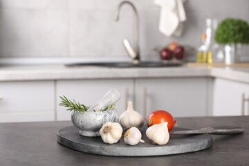 Fresh raw garlic, onion and rosemary on grey table