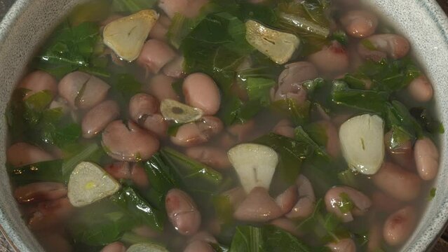 Escarole and pinto beans soup with fried garlic. Old world escarole with new world beans. Table spin.