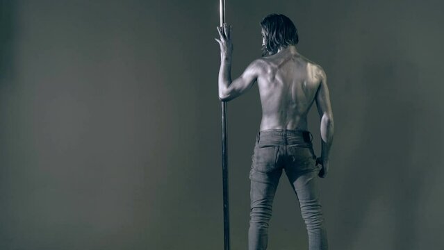 Flexible sexy body of young man. Pole dance. Sexy man exercise pole dance. Fit slim sexy man performs sensual pole dance. Go-go dancer. Strip dancer. Male athlete doing acrobatic trick on pylon.