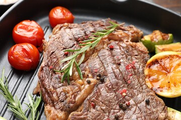 Delicious grilled beef steak and vegetables in frying pan, closeup