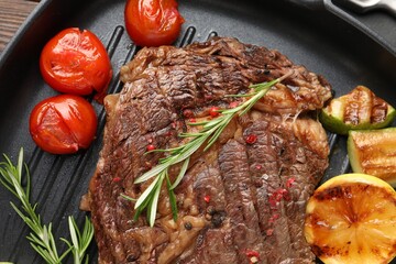 Delicious grilled beef steak and vegetables in frying pan, top view
