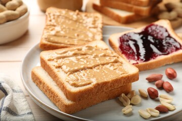 Delicious toasts with peanut butter, jam and nuts on table, closeup