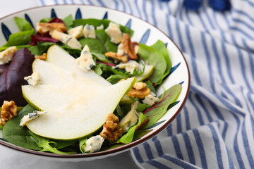 Delicious pear salad in bowl on table, closeup