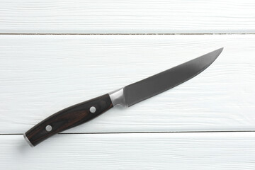 One sharp knife on white wooden table, top view