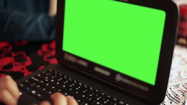 Young Man Using A Laptop Green Screen. Close-Up. You can replace green screen with the footage or picture you want with “Keying” effect in After Effects (check out tutorials on YouTube).