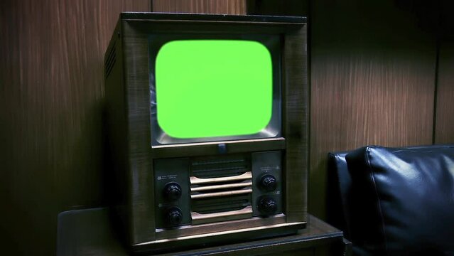 Antique Wooden Television Turning On Green Screen with Static Noise. Close Up. You can replace green screen with the footage or picture you want with “Keying” effect in After Effects.