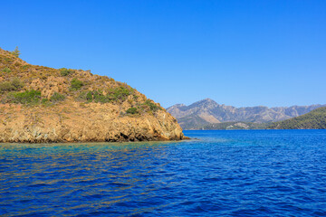 Obraz premium Rocky coast in the resort part of the Mediterranean or Aegean Sea. Background with selective focus and copy space