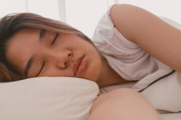 Close up of lazy Asian woman just wake up but not going to get up from the bed.