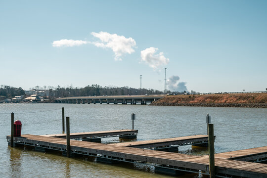 A boat dock in the foreground looking over Lake Wylie, South Carolina with the steam from a nuclear power plant in the background.