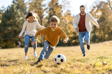 Active family play soccer in their leisure time - obrazy, fototapety, plakaty