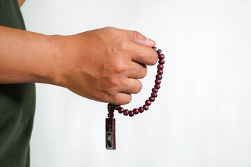 hand holding prayer beads isolated on a white background